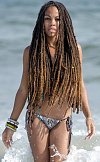 Hot bikini rasta babe emerges from the surf with her dreadlocks hanging long